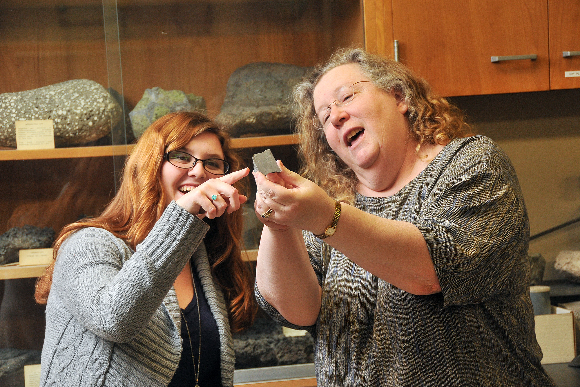 Geology instructor looking at rock with a student