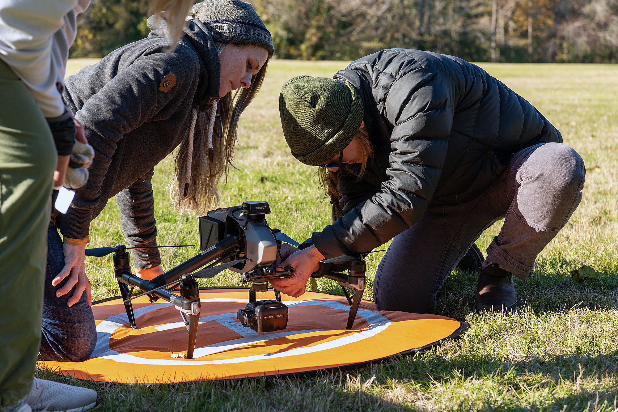 GIS students setting up a drone outside on campus