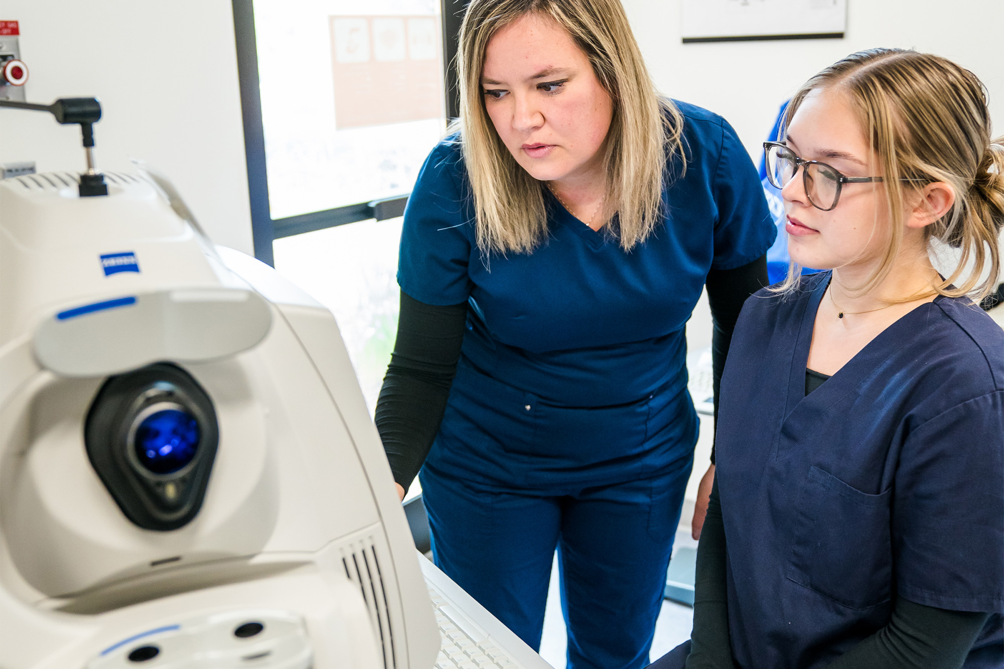 Medical Coding students working together at a computer in a medical office
