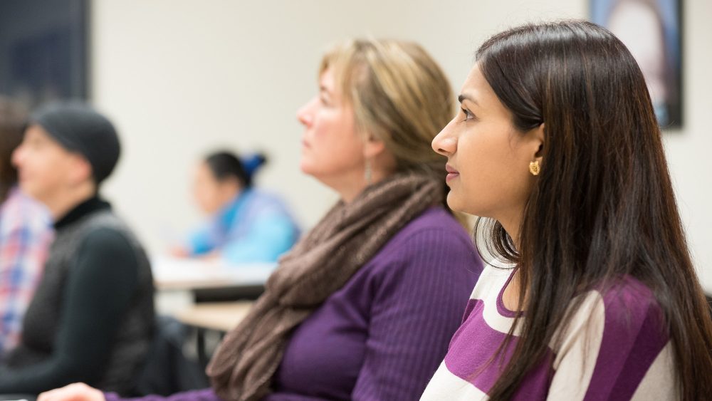 Women looking at white board in a classroom