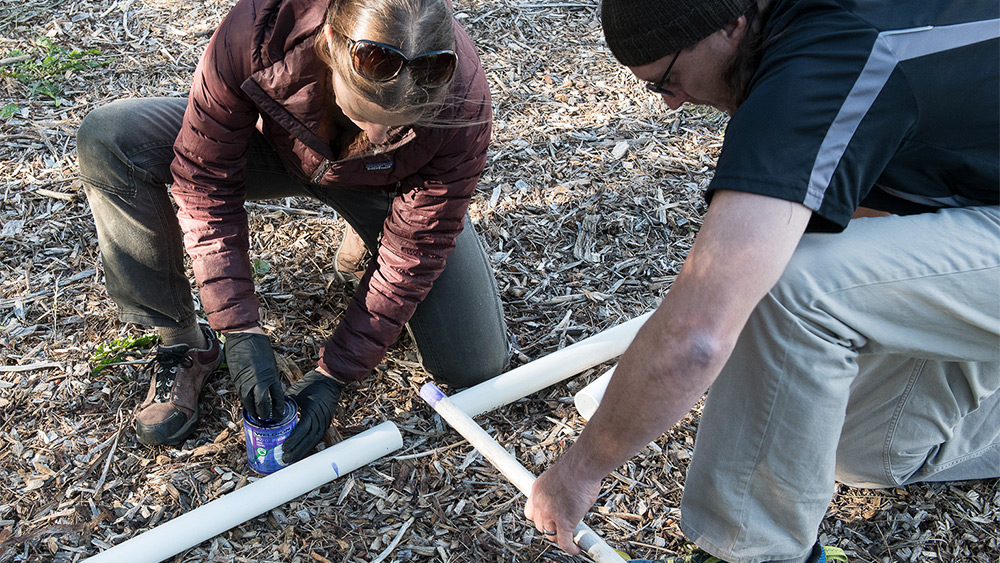 Students working with irrigation pipe