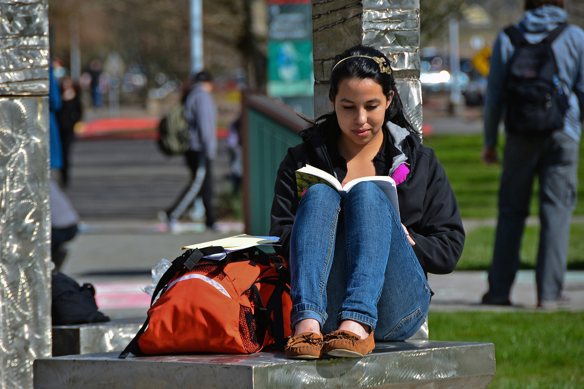 Literature student reading a book outside on campus