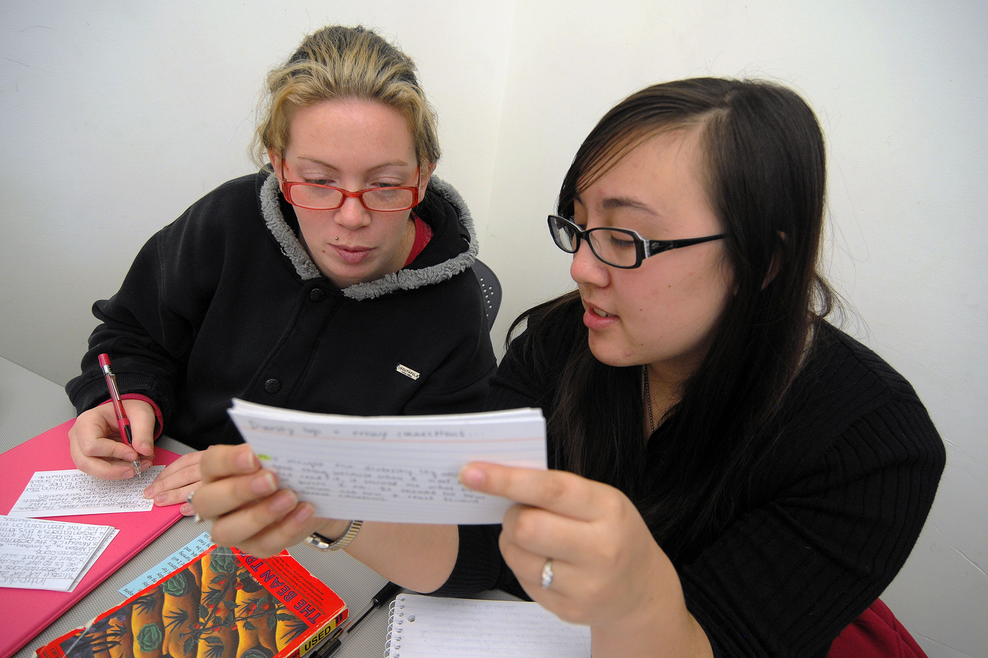 Literature students studying note cards together in a fiction class