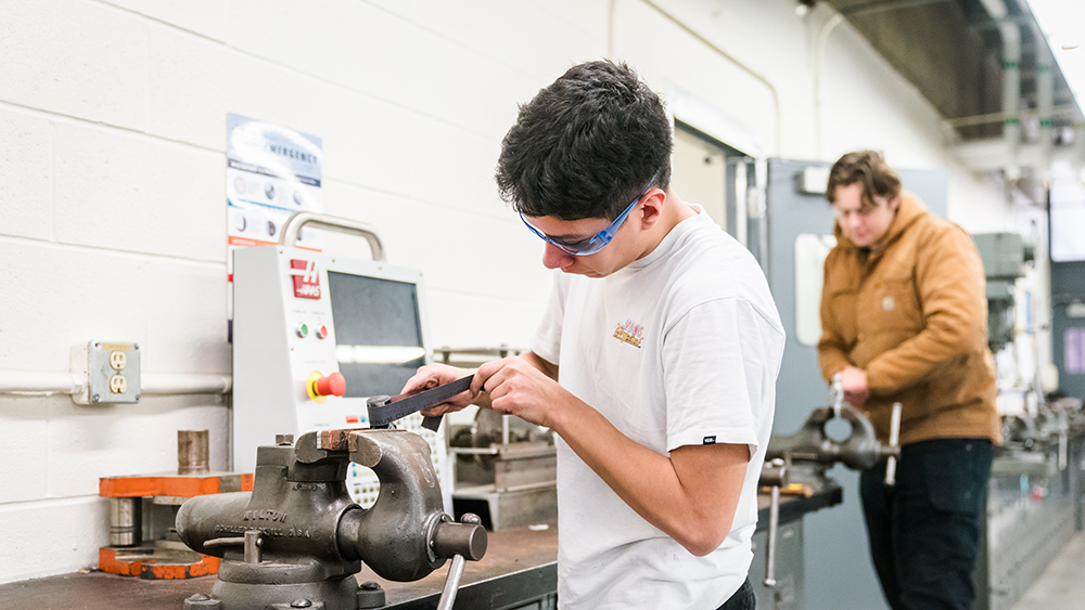 Student using hand tools in the machine manufacturing lab