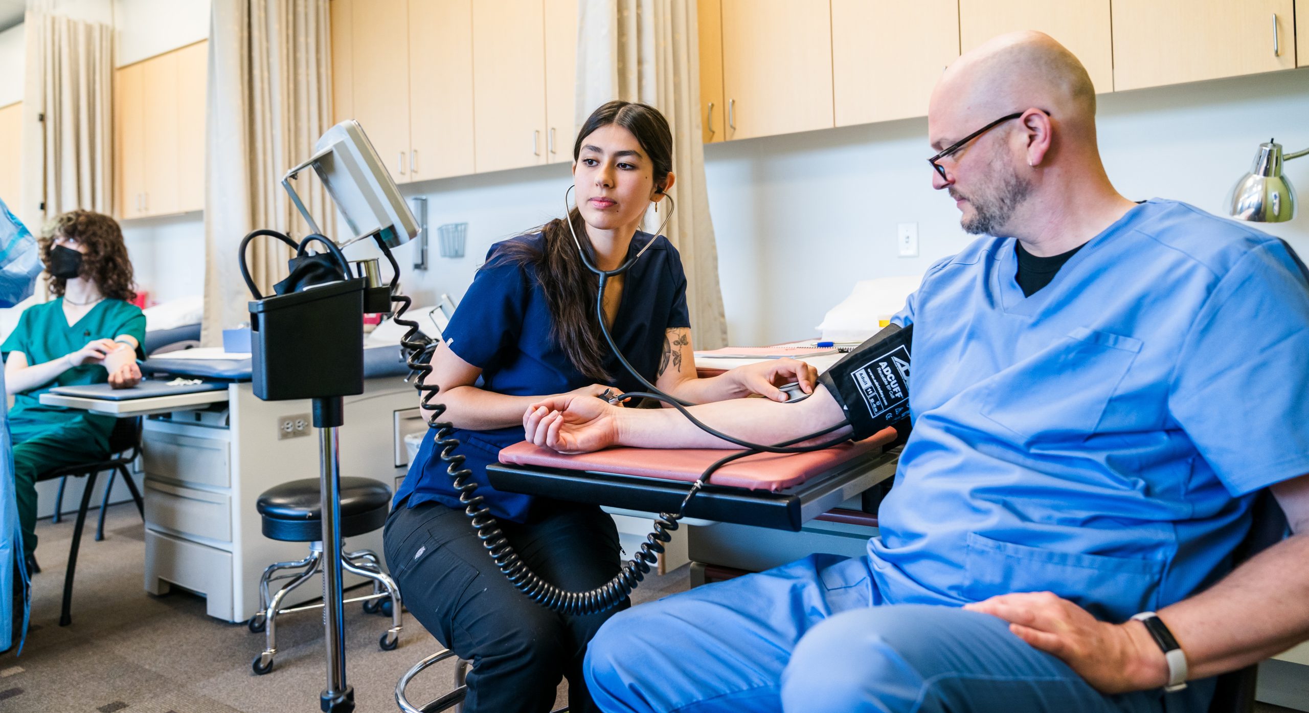 Medical student practicing with a blood pressure cuff