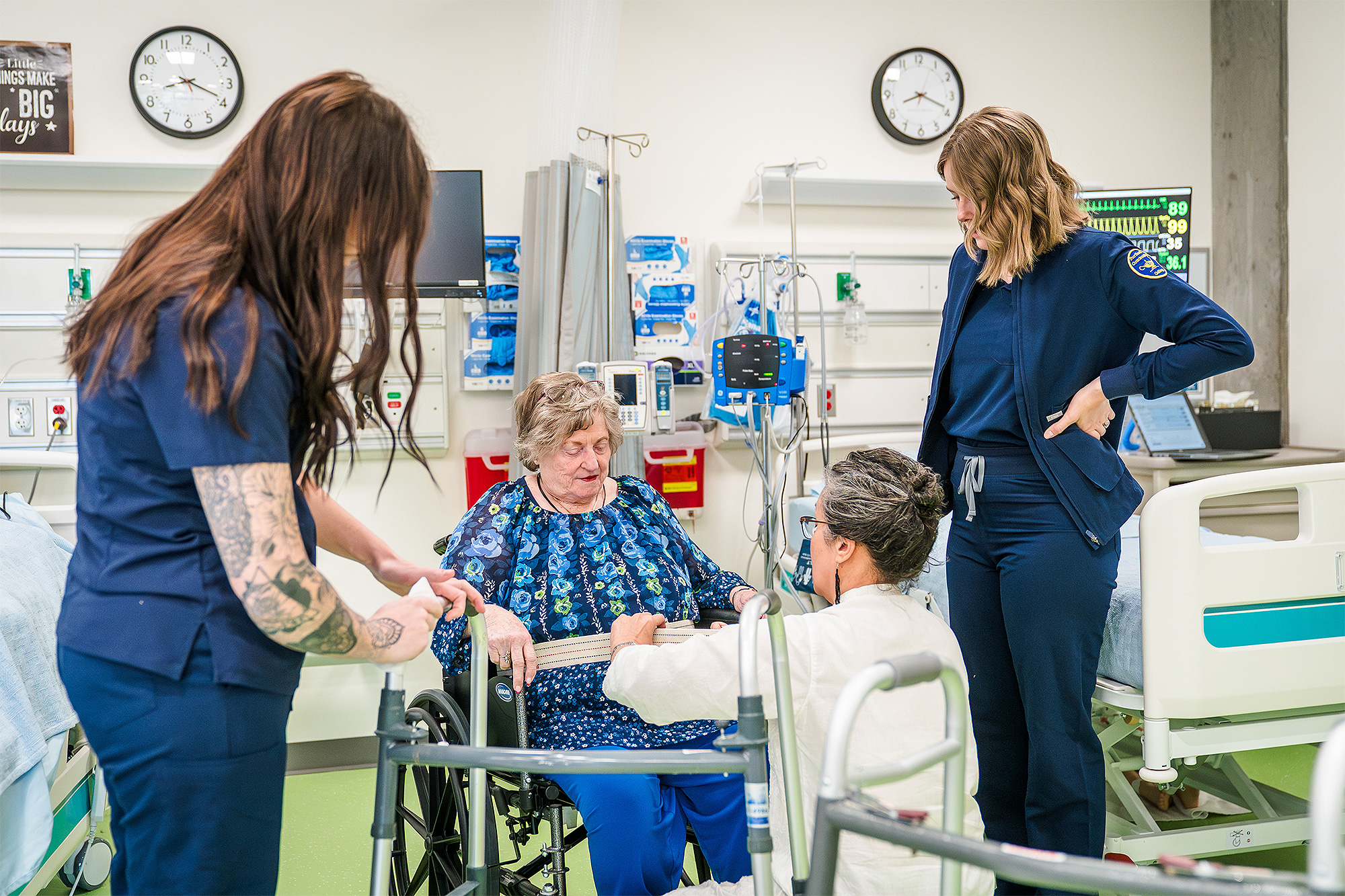 Medical students helping a mock patient in a wheelchair