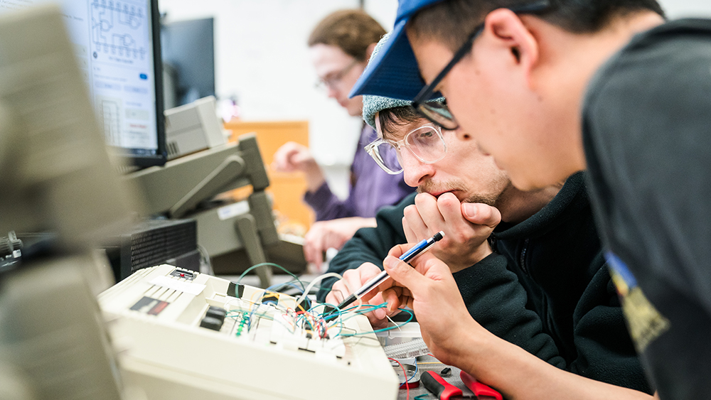 Microelectronic students working with tools together