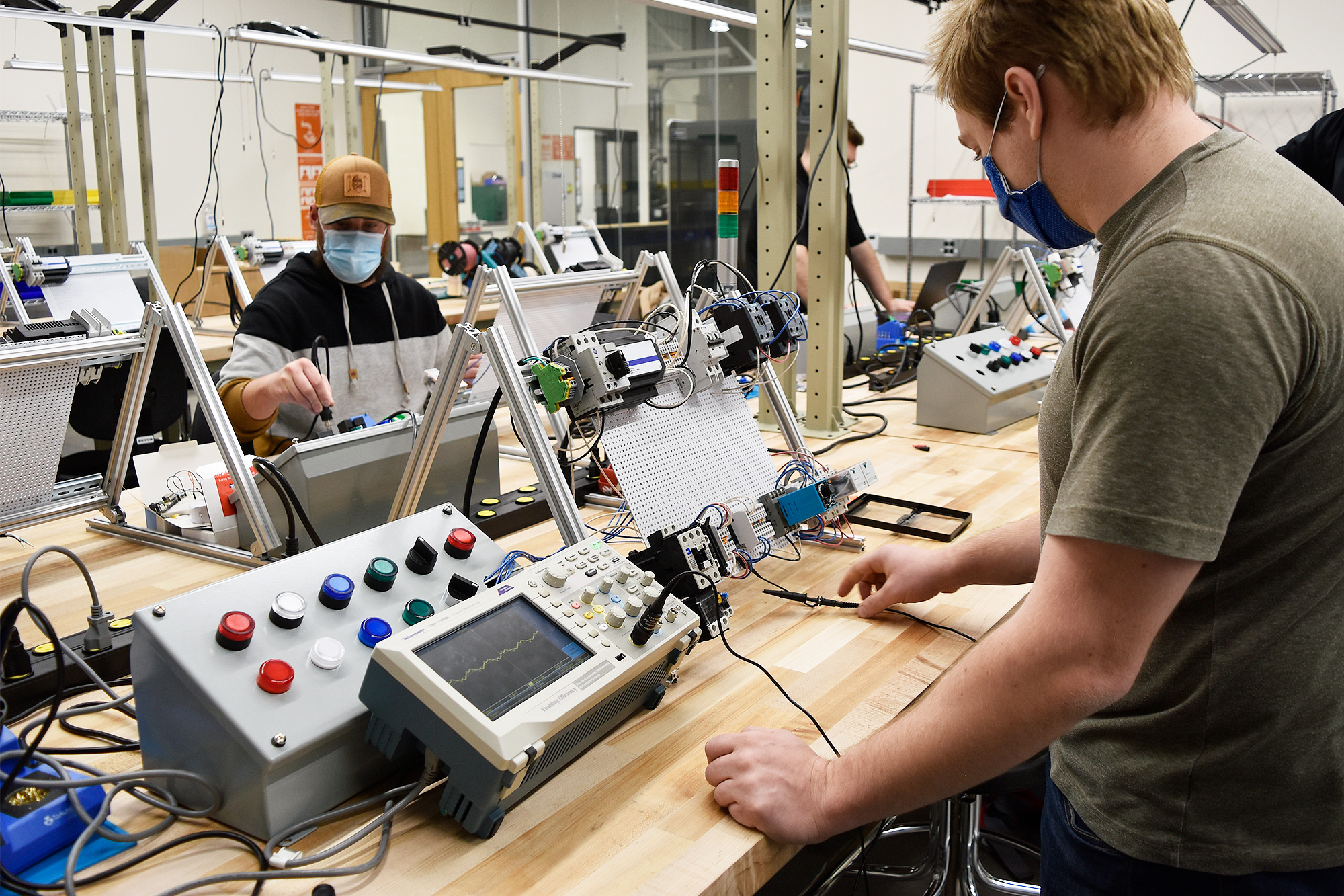 Microelectronics Technology students working with mechatronics equipment in the lab