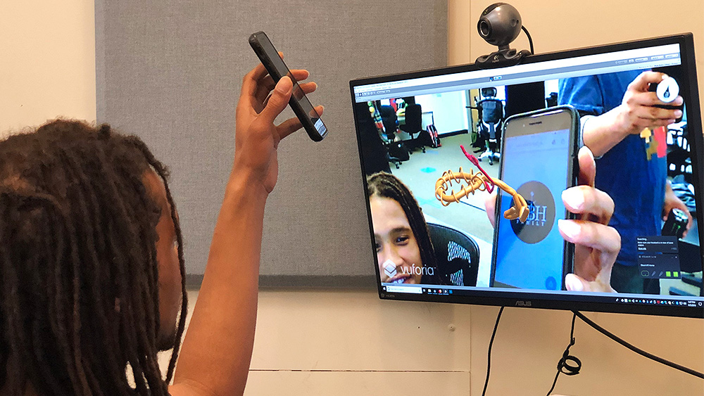 Student using virtual reality with a computer, webcam, and phone