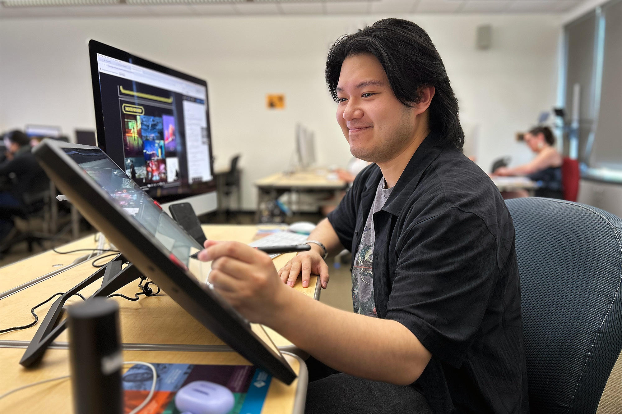 Multimedia student drawing on a graphic tablet in class