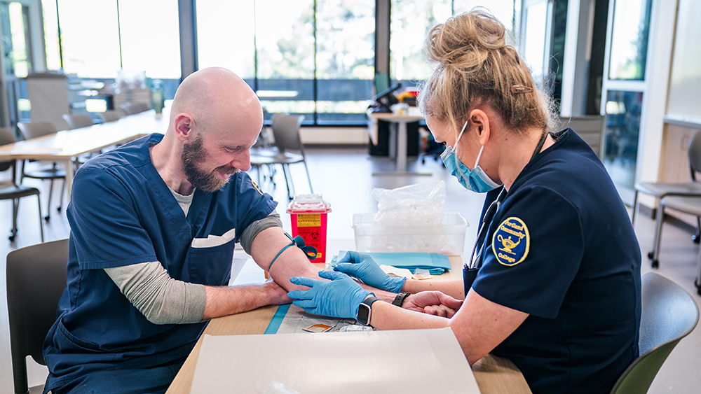 Nursing students drawing blood on each other