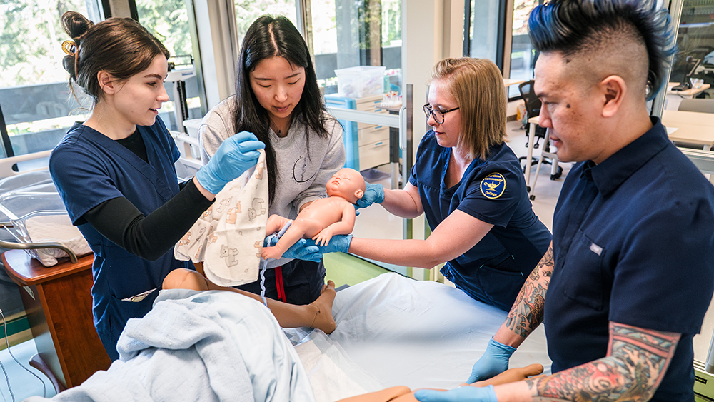 Nursing students practicing a birth with mannequins