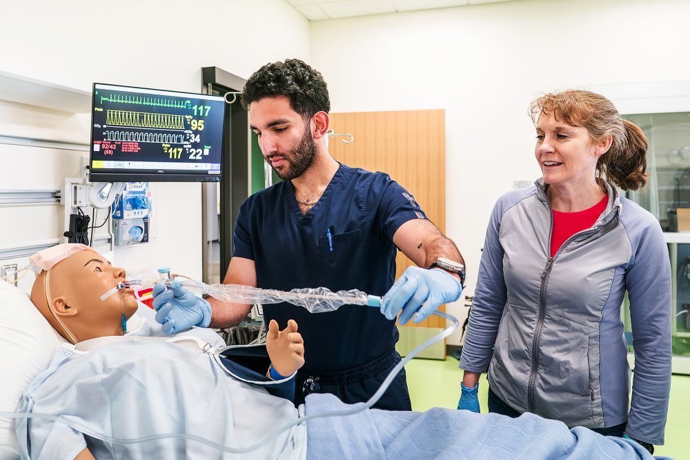 Nursing student practicing intubating a mock patient