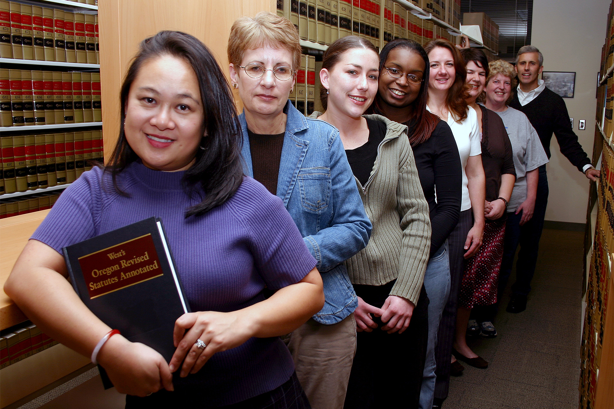 Paralegal students standing together in the paralegal library