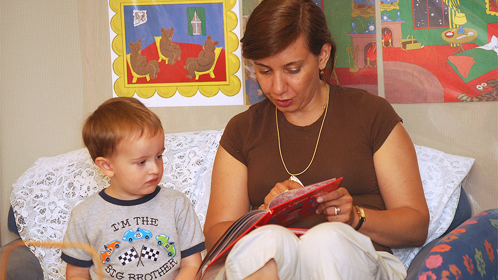 Mom reading to her child in a bedroom