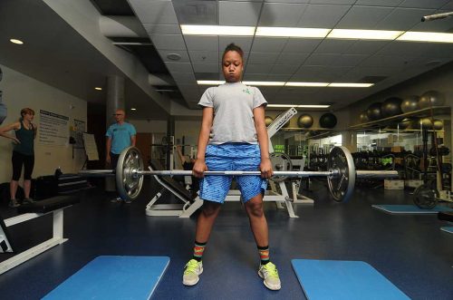 Student lifting weights in the weight room