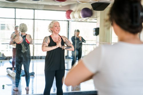 Students holding hands at their hearts in a stretching class