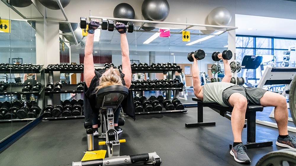 Students lifting weights in class