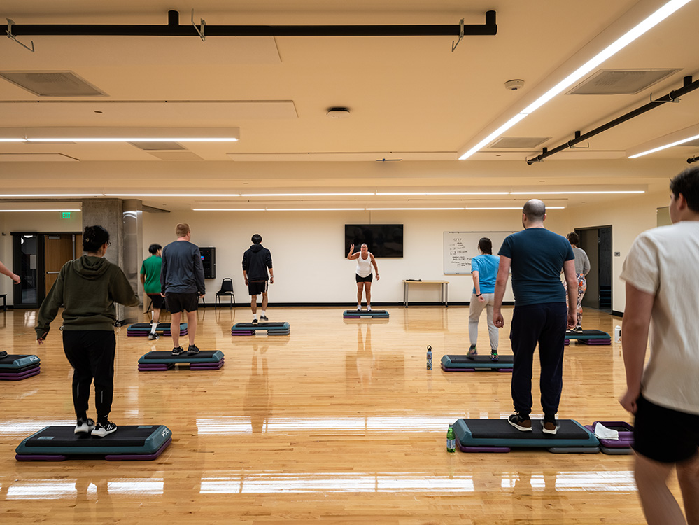 shiny wood floor studio with students on step mats