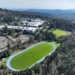 Aerial view showing the campus on the hill behind the track