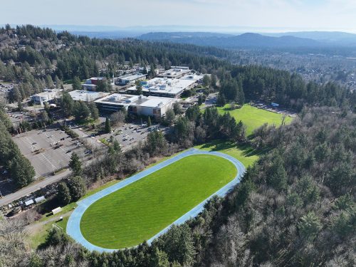 Aerial view showing the campus on the hill behind the track