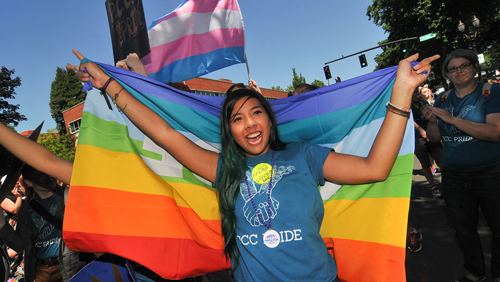 Student holding pride flag and wearing PCC shirt