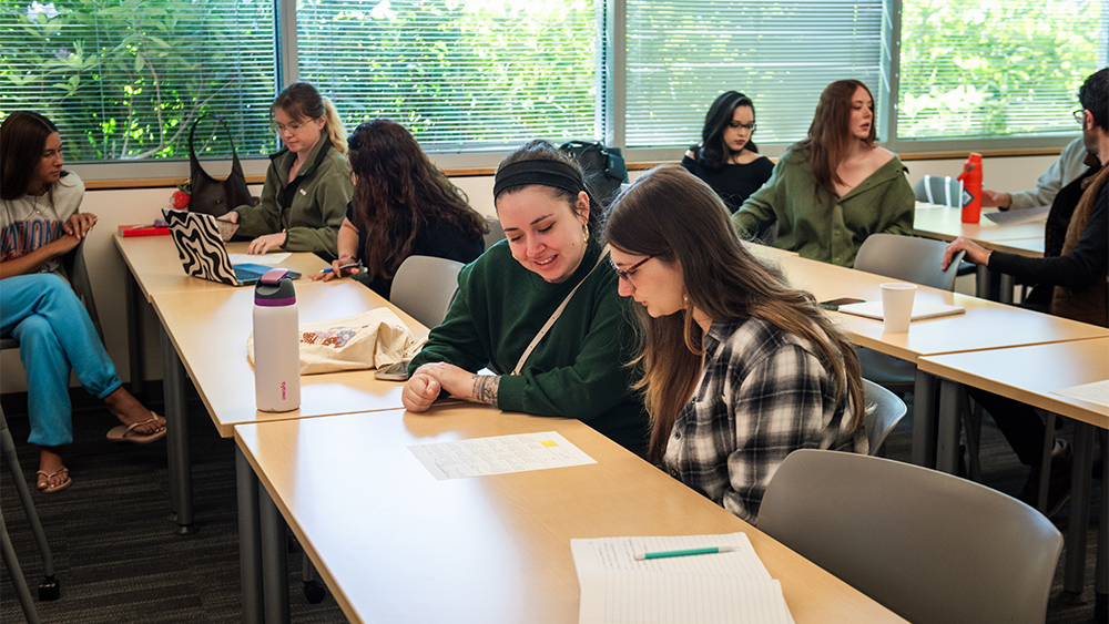 Students studying a handout in class together