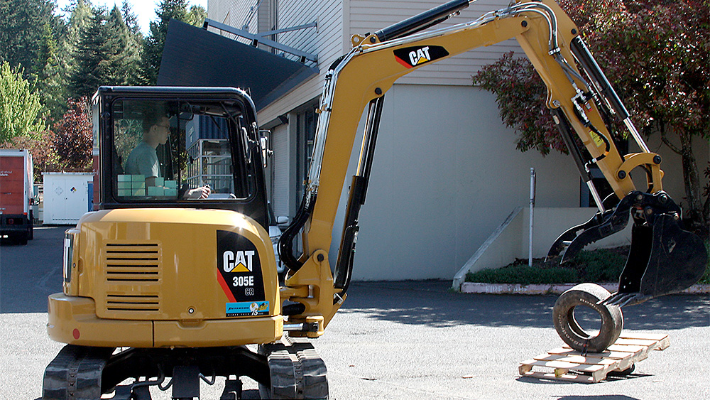 Student driving a CAT backhoe