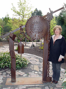 Bell hanger sculpture with Alisa standing next to it