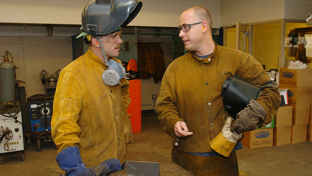 Students talking to each other in the welding shop