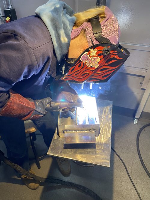 Student welding with protective gear