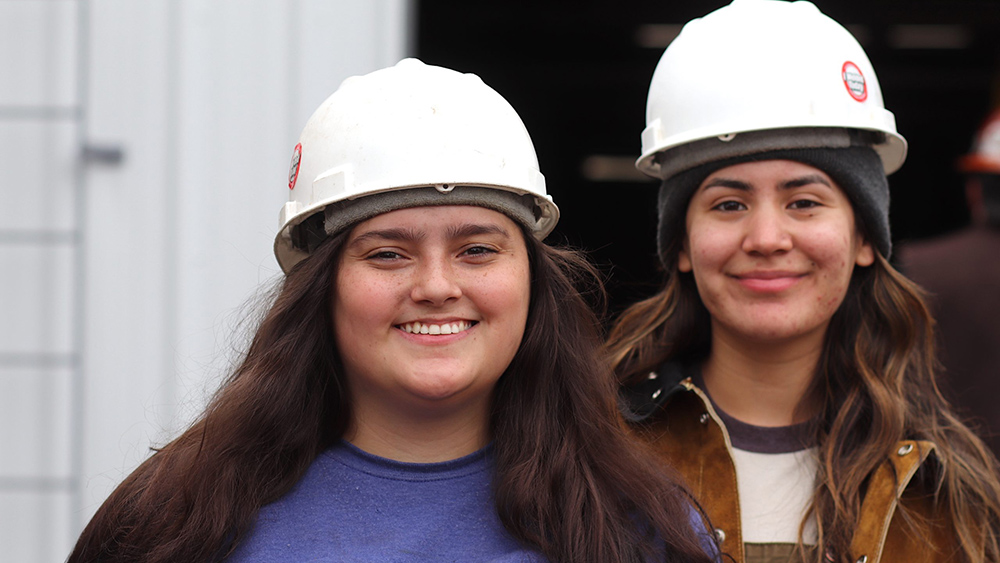 Two welding students with hard hats on