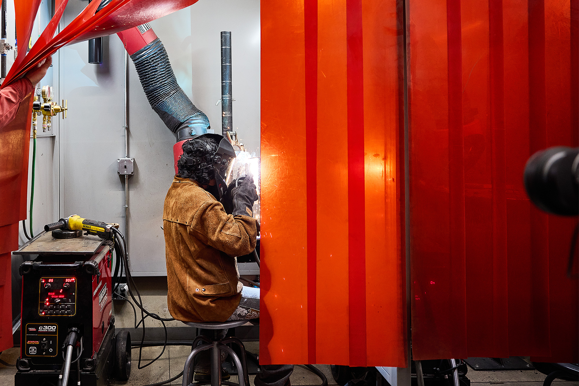 Student welding in a booth in the PCC welding shop