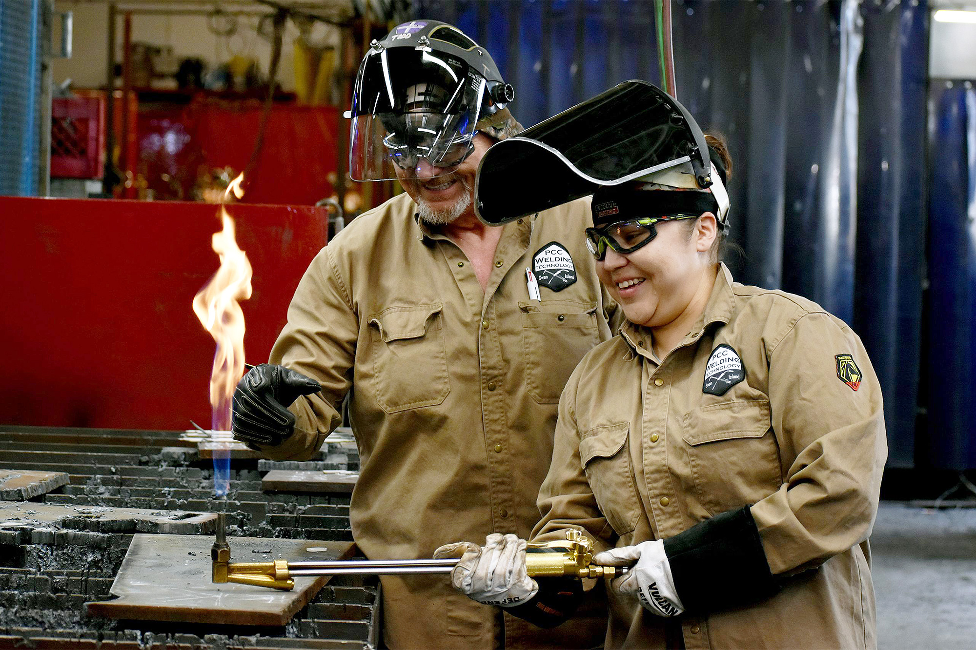 Maritime welding students holding a lit torch