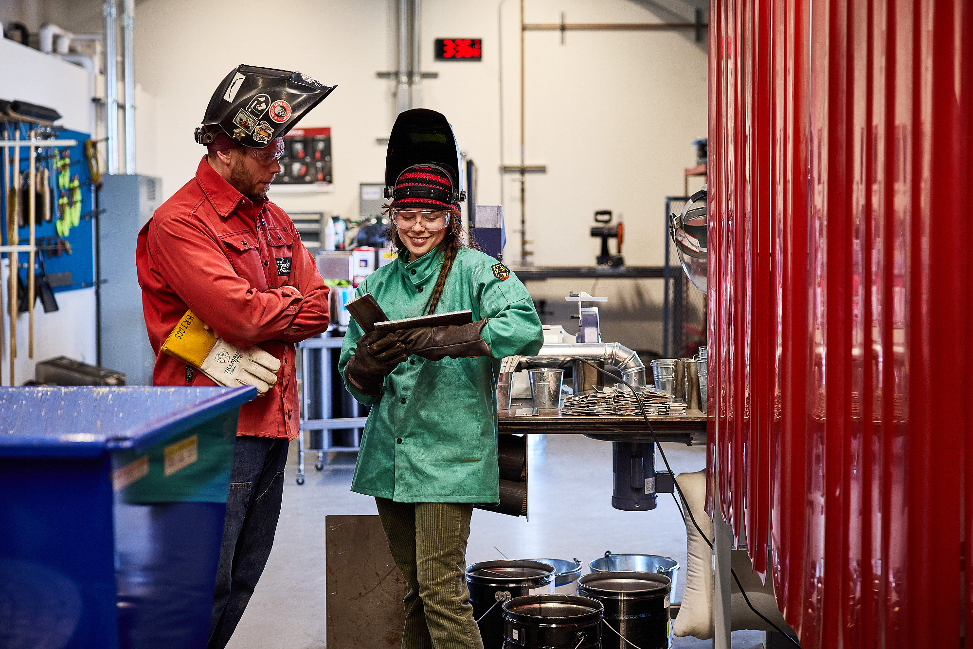 Welding instructor talking to a student in the shop