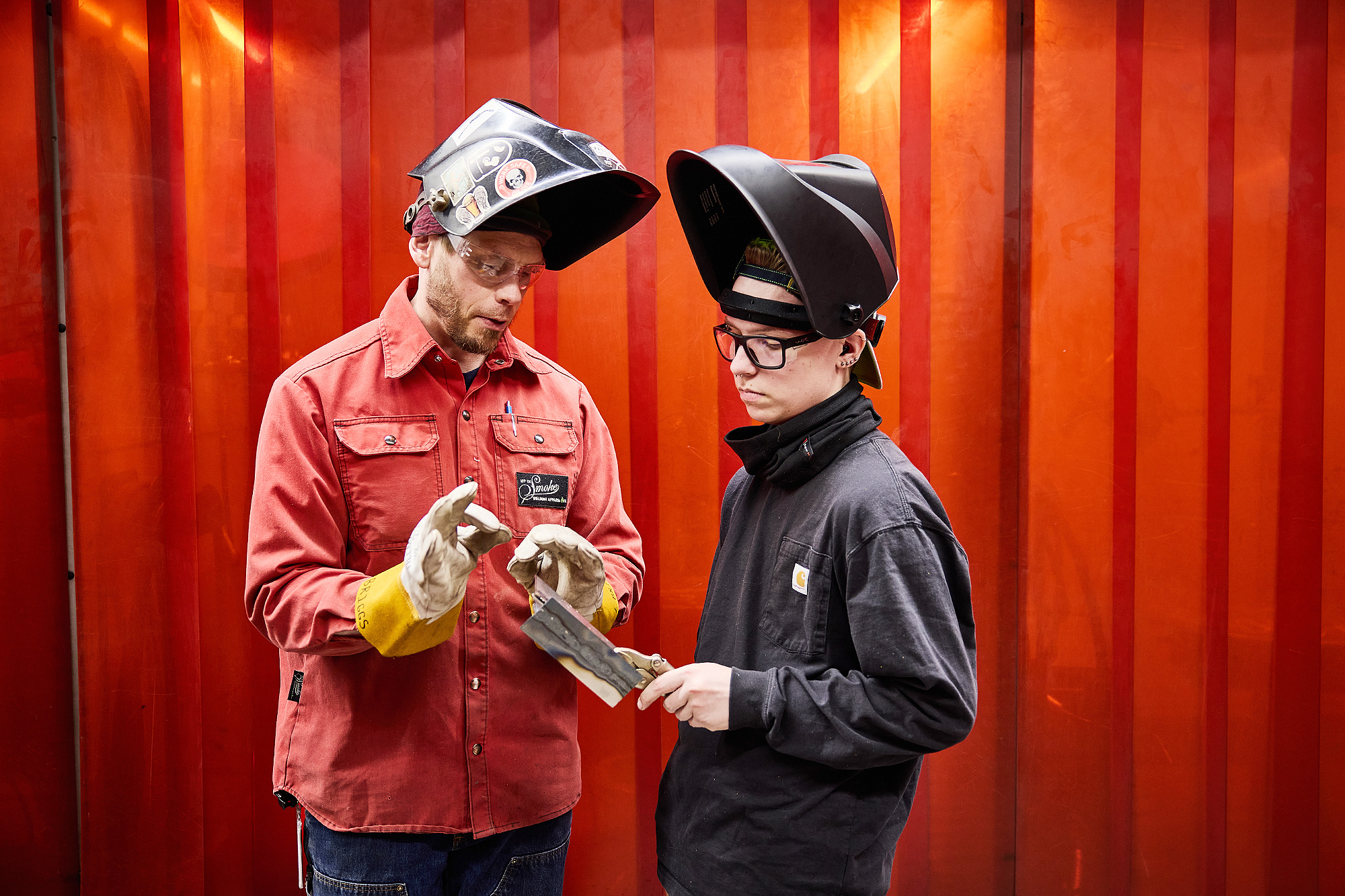 Welding instructor talking to a student in the shop