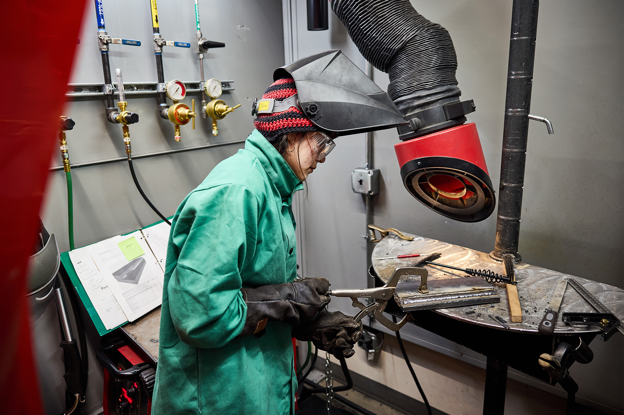 Welding student setting up her metal in the welding booth
