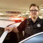 Public safety officer standing next to car