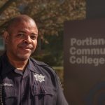 Officer standing by PCC sign