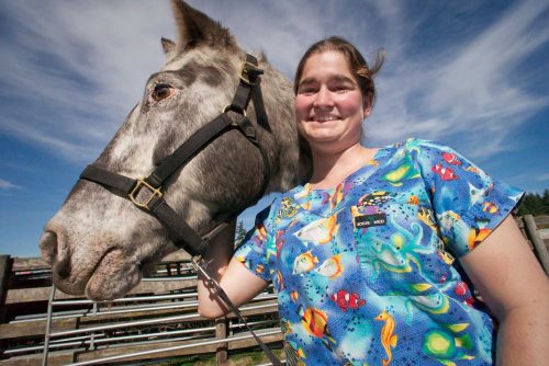 Vet tech student standing with a horse