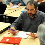 Small groups of SBDC business clients discuss growth strategies at tables in CLIMB classroom.