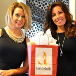 Bombshellers business women smiling with a gift bag of their product