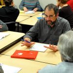 Group of people at table discusses business training in CLIMB classroom