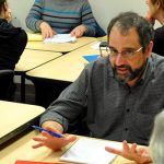 Group of people at table discusses business training in CLIMB classroom