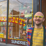 Business Builders alumnus stands outside of his storefront