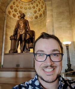 picture of Eric Dodson in front of a statue
