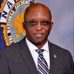 Instructor with FBINA flag in background