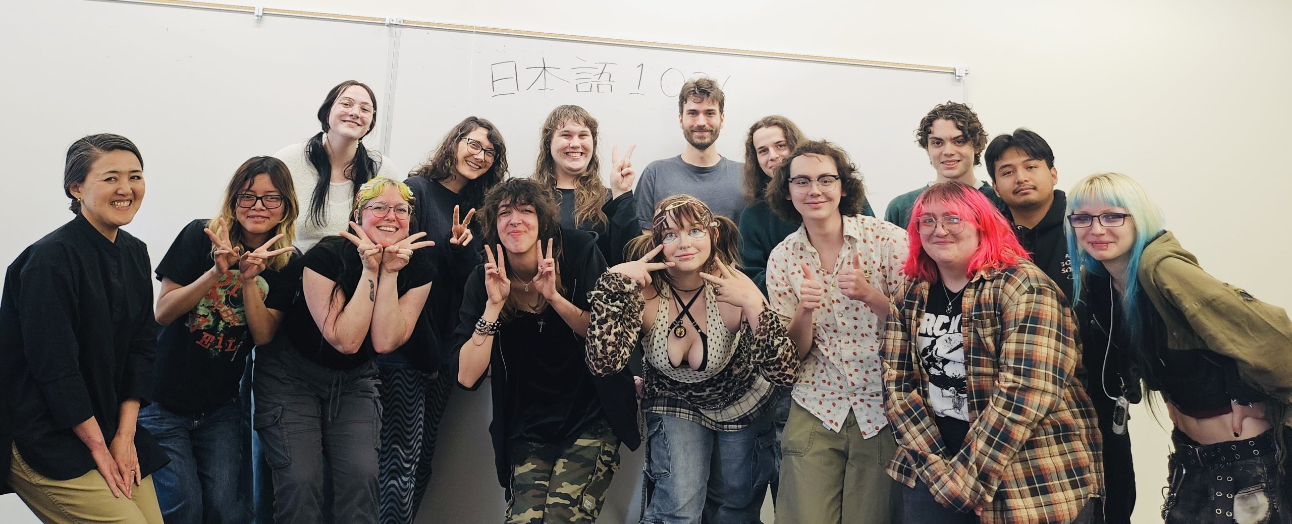 JPN103 Students and Yumiko Omata posing in front of a classroom whiteboard