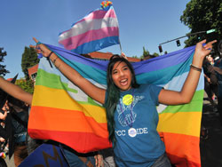 Student holding a pride flag at a parade