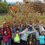 People tossing fall leaves